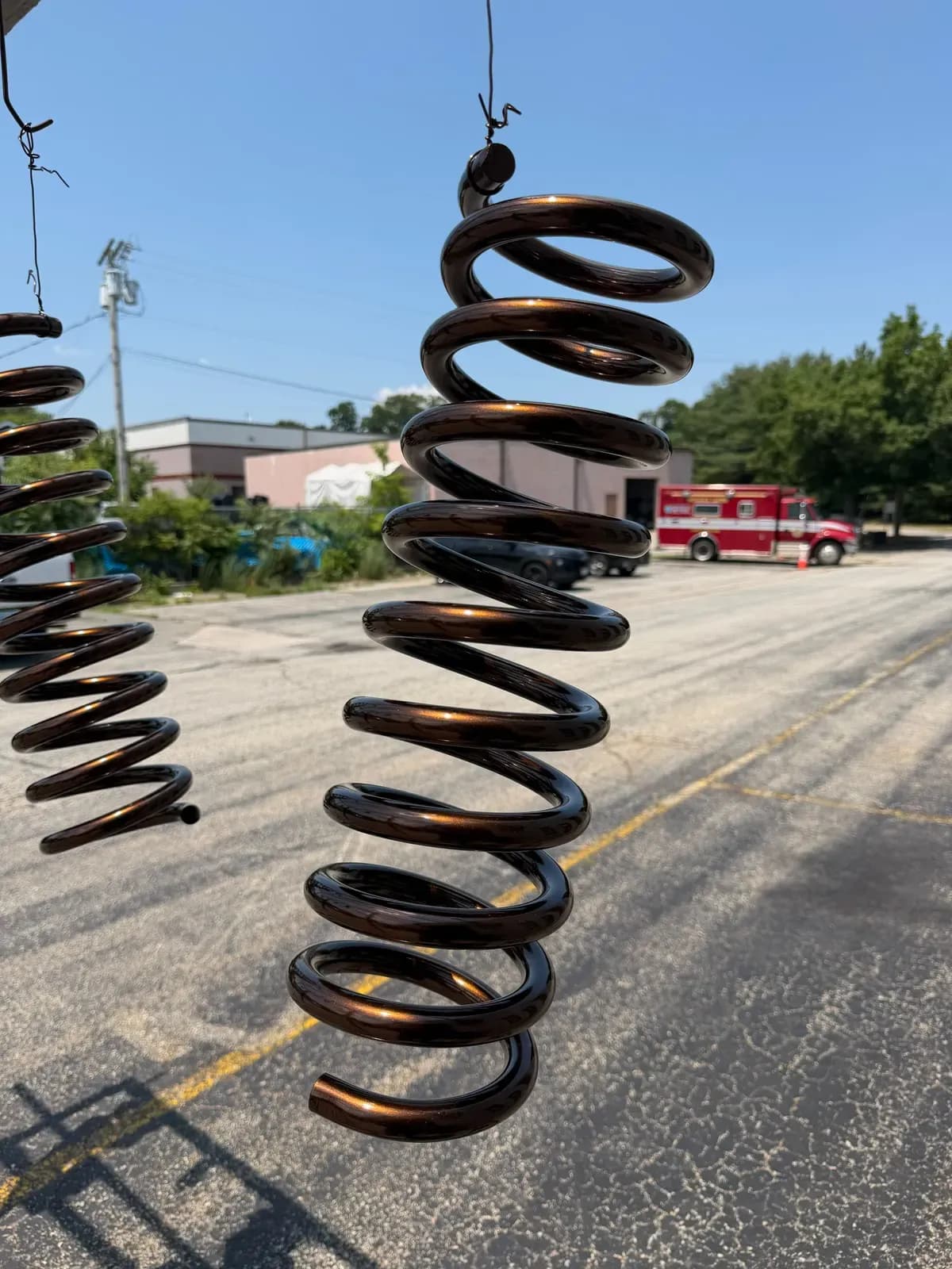 Coil springs powder coated in bronze hanging outside the shop